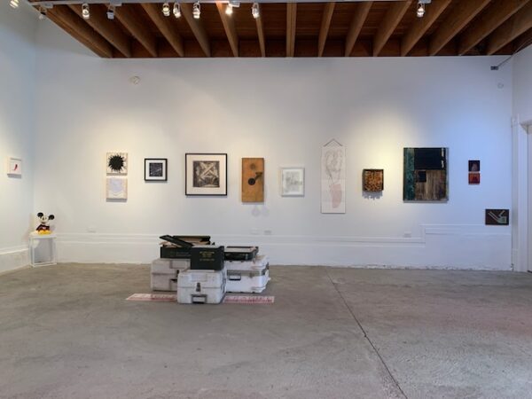 Exhibition view of numerous small works installed on the wall and on the floor. Paintings, drawings and sculptures are seen.